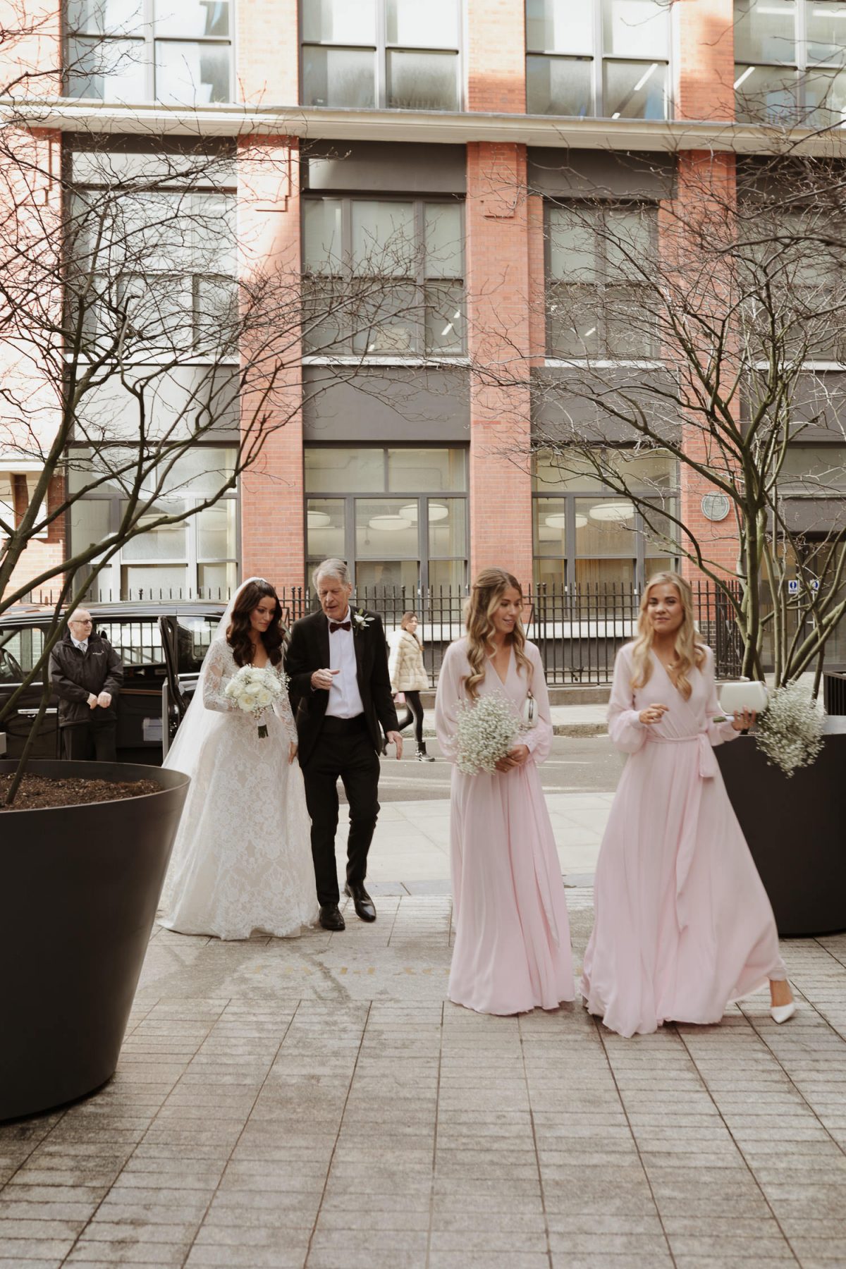 bride and bridesmaids walking down to fitzrovia chapel wedding